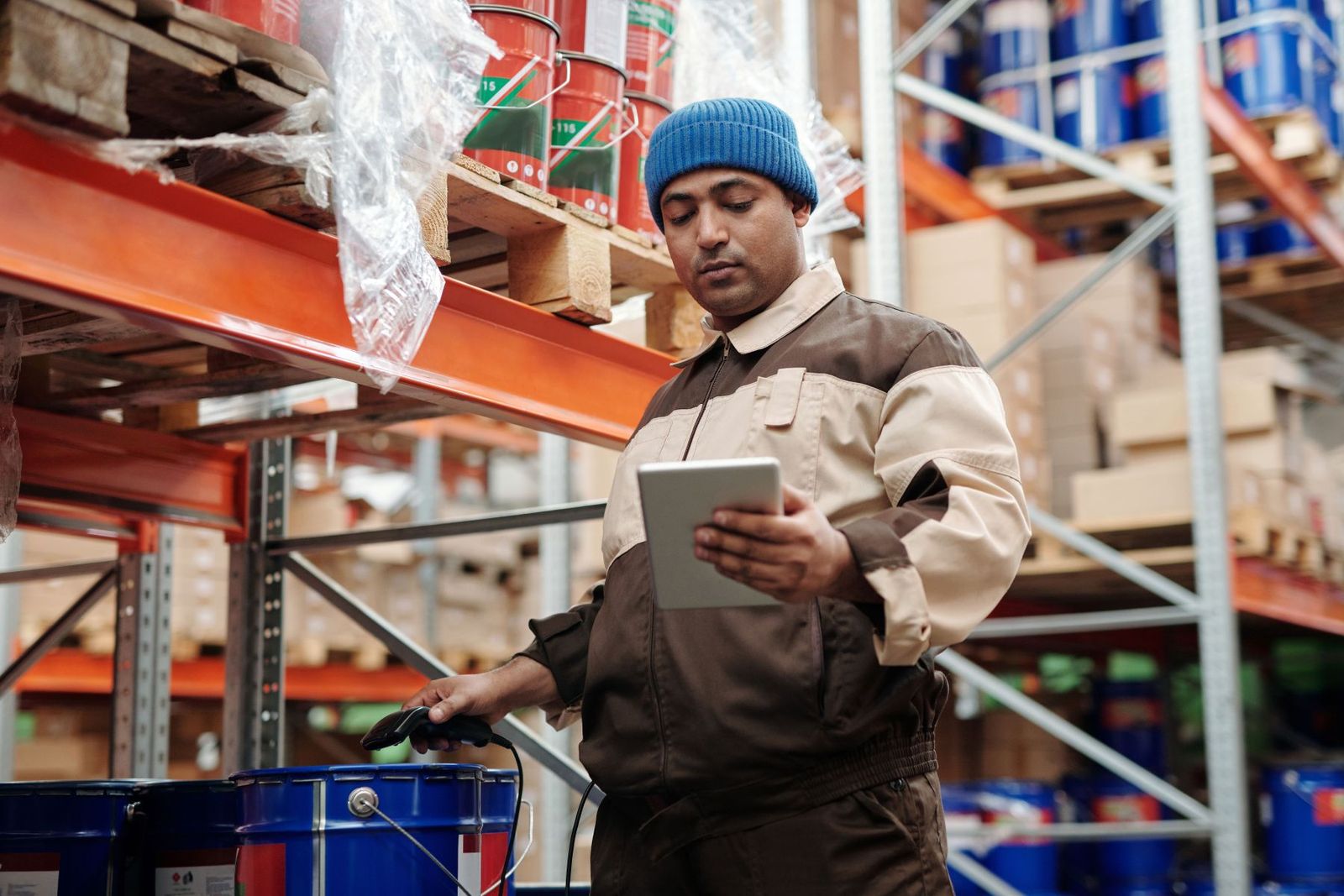 A worker logging materials with a tablet and a barcode scanner instead of on paper